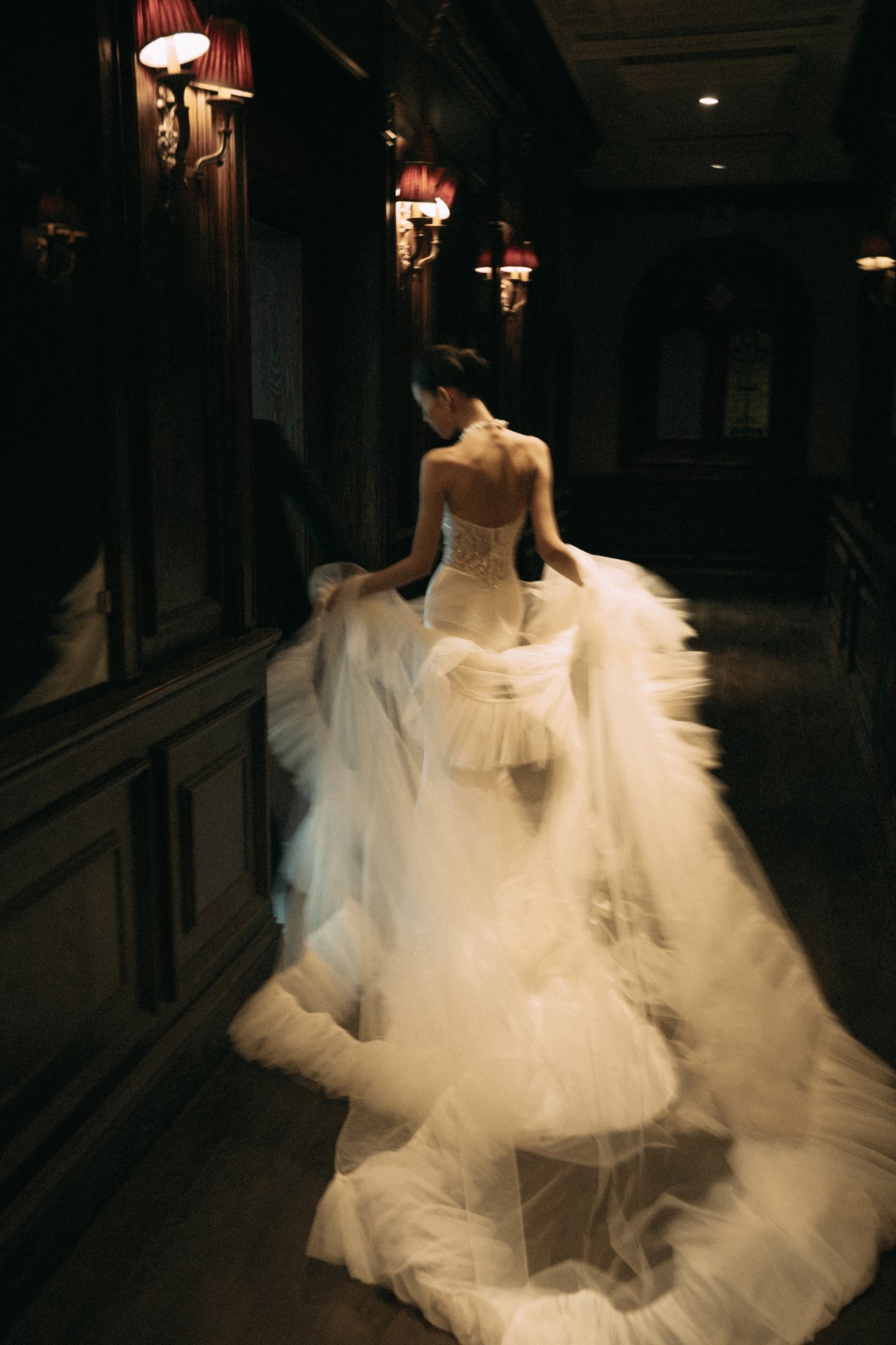 Bride moving through a softly lit corridor