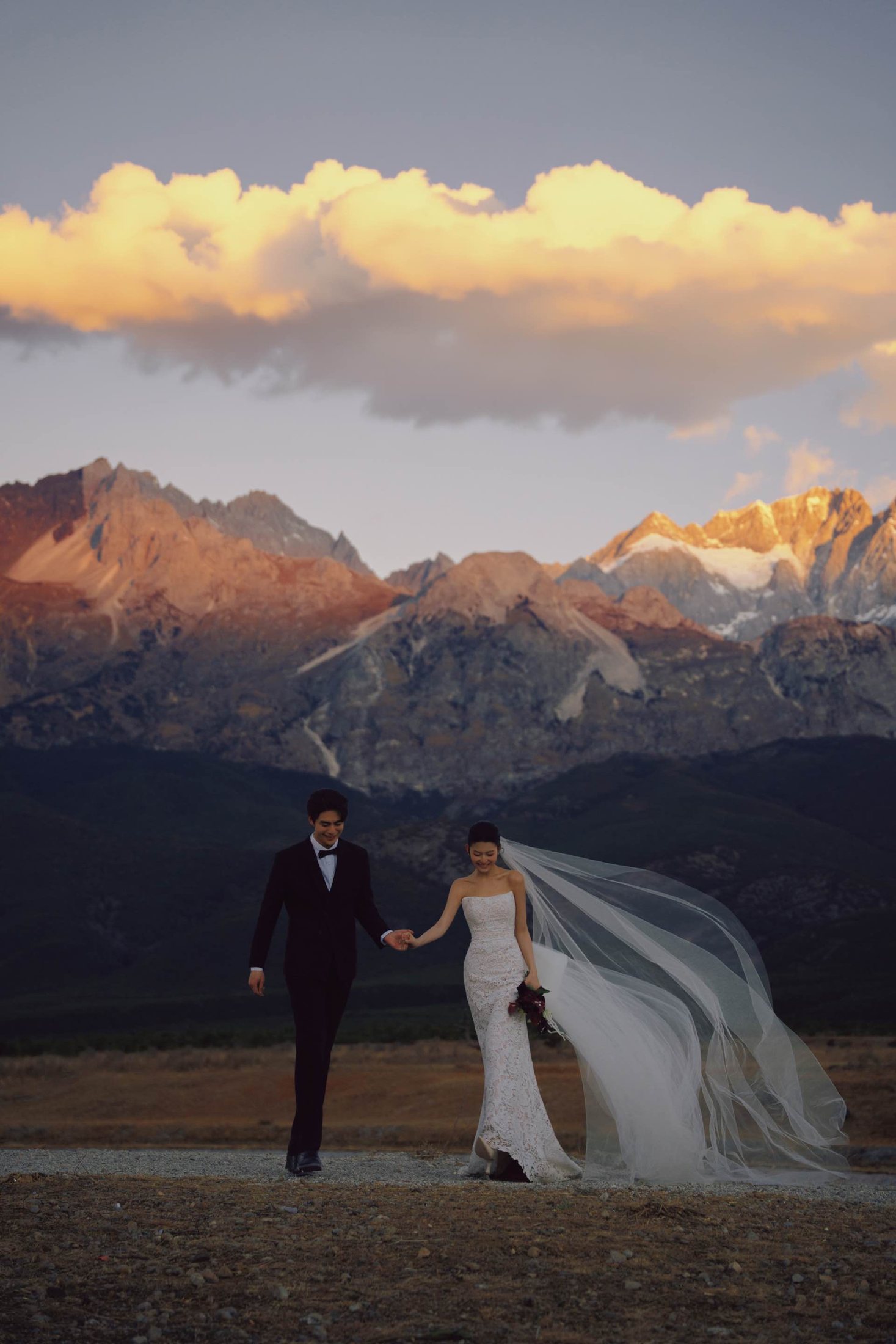 Couple walking below dramatic mountains
