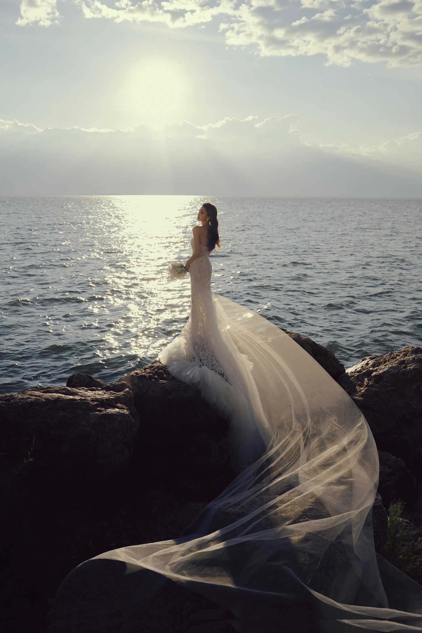 Bride standing by the water in golden light